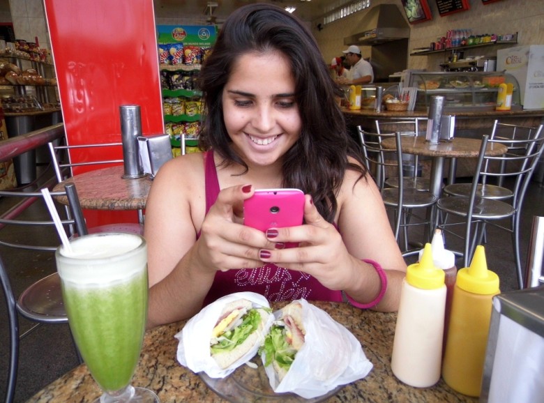 A surubinense Mayara Cabral, esquecendo de se alimentar para mexer no seu adorado smartphone | Foto: ilustração