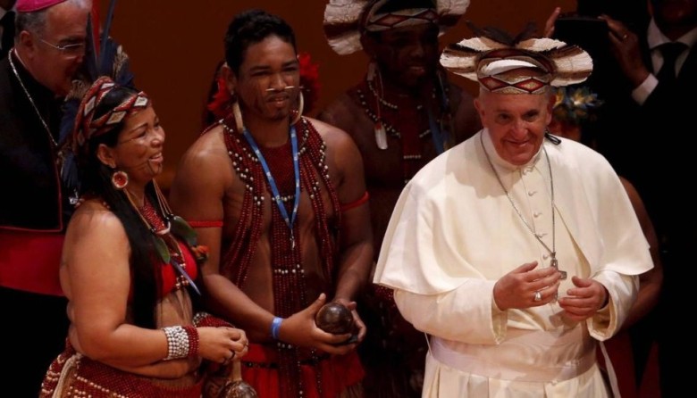O Papa Francisco usa um cocar que ganhou dos índios no Teatro Municipal - Mônica Imbuzeiro / Agência O Globo