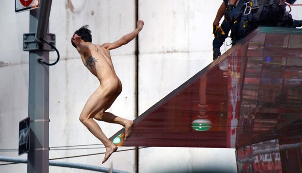 Homem nu pula de arquibancada na Times Square, em Nova York (Foto: AP)