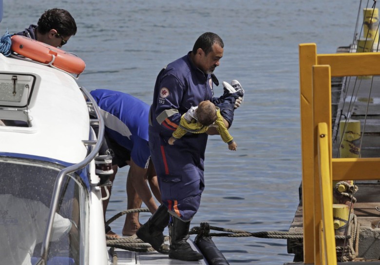 Socorrista do Samu leva um bebê no colo após uma embarcação naufragar em Mar Grande, na Baía de Todos-os-Santos, na Bahia (Foto: Xando Pereira/Agência A Tarde/Estadão Conteúdo)