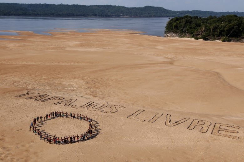 Ativistas do Greenpeace e índios Munduruku usam pedras para formar a frase "Tapajós Livre" nas areias de uma praia às margens do rio de mesmo nome, próximo ao município de Itaituba, no Pará. O protesto, que contou com a participação de cerca de 60 Munduruku, ocorreu na região onde o governo pretende construir a primeira de uma série de cinco hidrelétricas na bacia do Tapajós. (©Greenpeace/Marizilda Cruppe)